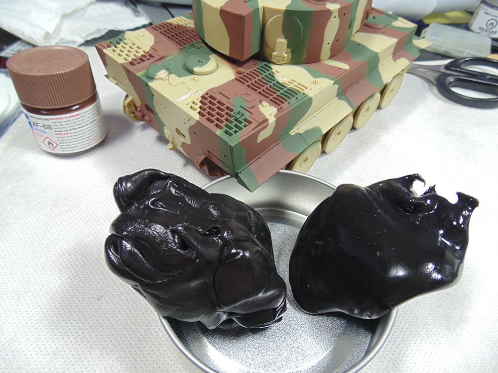 Two lumps of black putty with completed camouflage