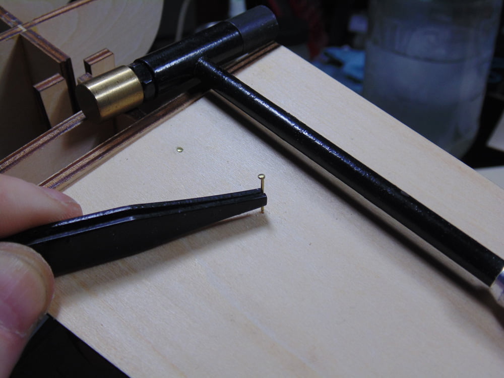Tweezers Holding Nail with Hammer