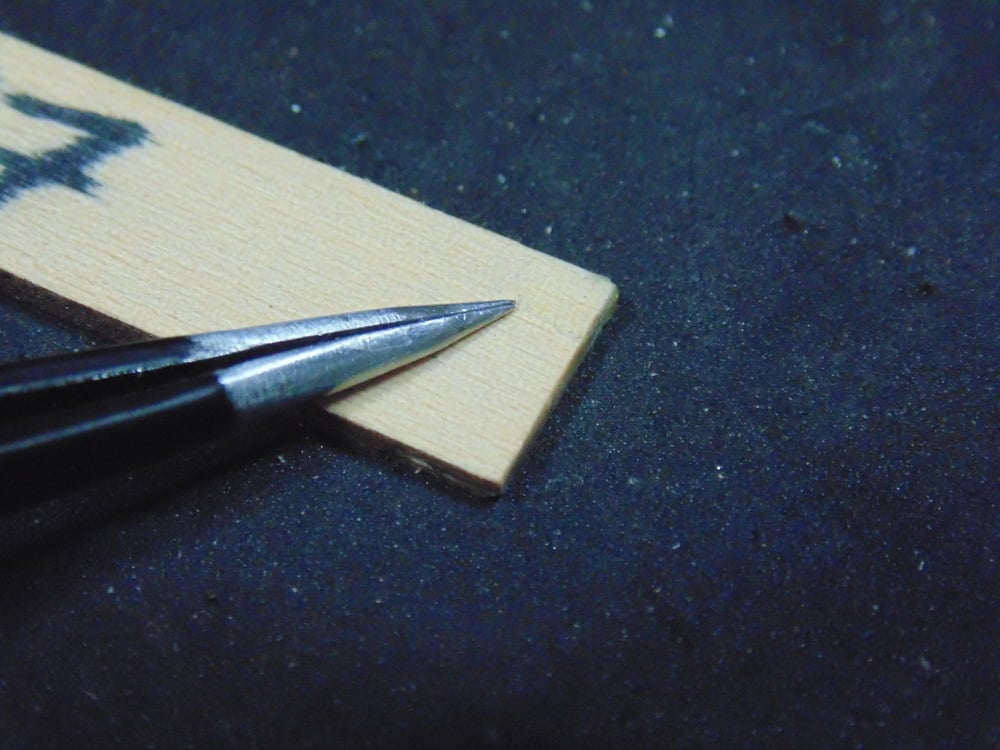 Tweezers Pointing to Glue Mark on Spacer