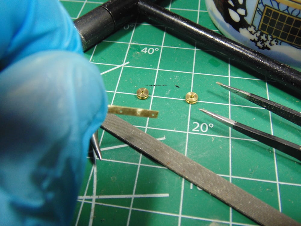 Brass Part with Drilled Holes Above Tools