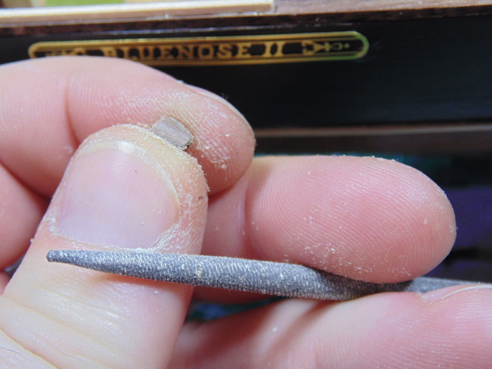Holding Part and Round File in Fingers