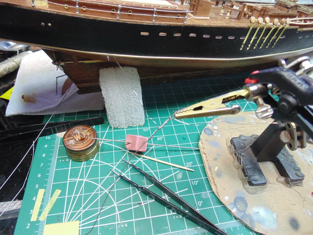 Second Hands Holding Cable End and Tweezers on Mat