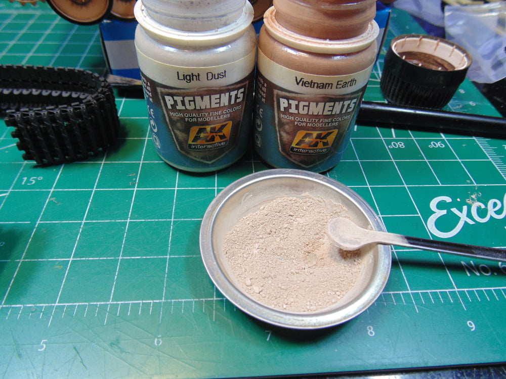 Mixed pigments in a metal cup with a paint spoon