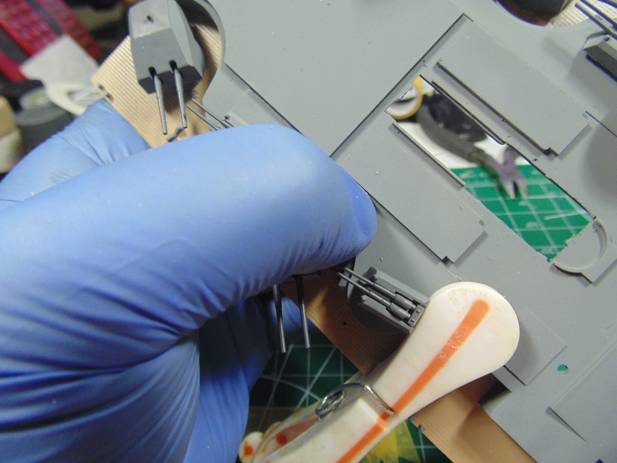 Blue gloved hand holding down AA parts