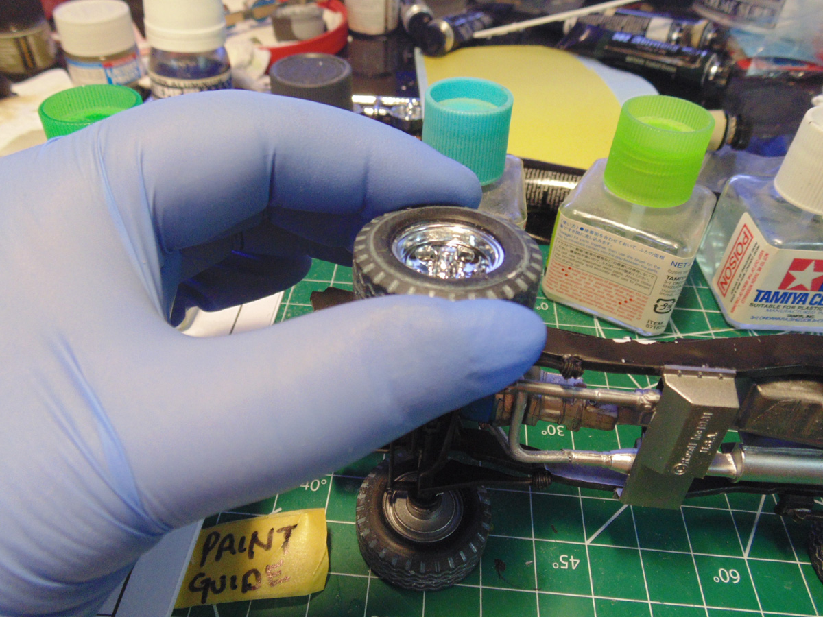 Blue glove holding a front wheel